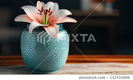 Mortuary urn with ribbon and flower on table against dark background. Dark ceramic urn placed beside soft Lilies Mortuary urn with ribbon and flower on table against dark background. Dark ceramic urn placed beside soft Lilies 132410906