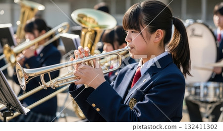 High school girl playing the trumpet outdoors (brass band club) High school girl playing the trumpet outdoors (brass band club) 132411302