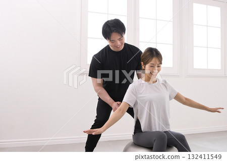 Young woman receiving training from a personal trainer Young woman receiving training from a personal trainer 132411549