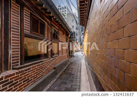 A narrow, traditional alley on Yulgok-ro 10-gil featuring Hanok architecture and brick walls 132411637