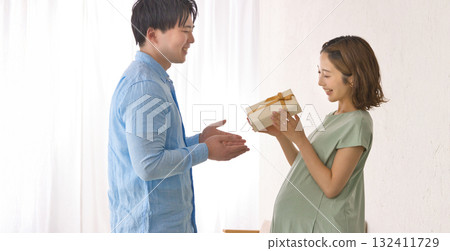 Young partner giving a gift to a pregnant woman Young partner giving a gift to a pregnant woman 132411729