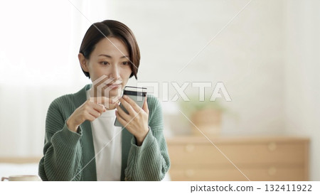 Woman operating a mobile phone 132411922