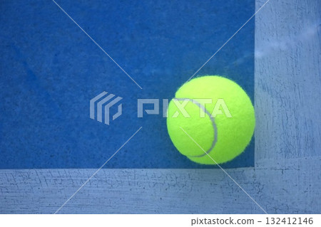 yellow tennis ball drop court with white border line on blue floor 132412146