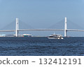 A sightseeing boat crossing the Yokohama Bay Bridge under a blue sky 132412191