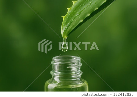 Drop dripping from aloe vera leaf into glass bottle, symbolizing health care. Drop dripping from aloe vera leaf into glass bottle, symbolizing health care. 132412823