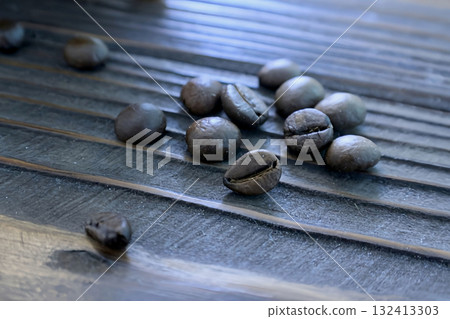 Aromatic coffee beans are scattered on a wooden table 132413303