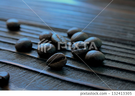 Several coffee beans are scattered on a wooden table Several coffee beans are scattered on a wooden table 132413305