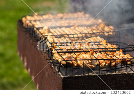Golden Chicken Meat Cooking on Hot Grill Grid with Smoke Golden Chicken Meat Cooking on Hot Grill Grid with Smoke 132413602
