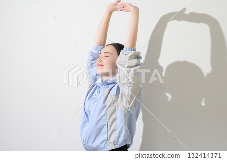 一個穿著運動服和伸展運動的女人 132414371