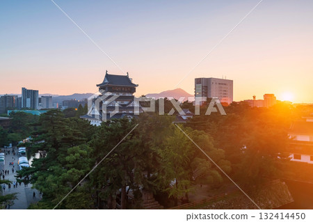 Kokura Castle by park and cityscape at sunset, Kitakyushu 132414450