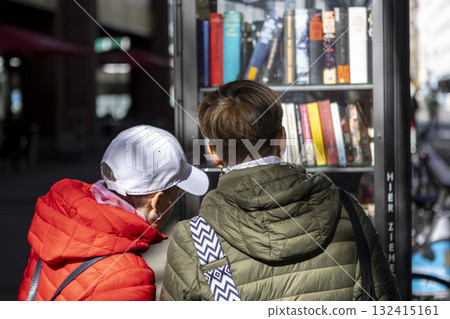 two people near a bookcase on a street in Cologne two people near a bookcase on a street in Cologne 132415161