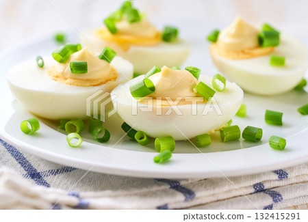 boiled chicken eggs with mayonnaise and freshly cut chives on a wooden table, healthy breakfast concept. boiled chicken eggs with mayonnaise and freshly cut chives on a wooden table, healthy breakfast concept. 132415291