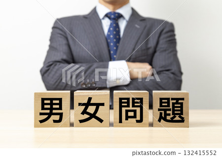 A businessman with his arms crossed and a block that reads "gender issues" A businessman with his arms crossed and a block that reads "gender issues" 132415552