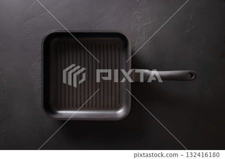 Empty cast iron grill pan with handle on black background. View from above. 132416180