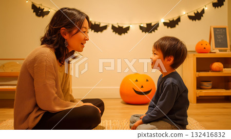 秋天，母子倆在室內萬聖節裝飾前微笑交談 132416832
