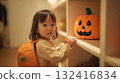 秋夜的室內，一個背著橘色背包的女孩看著南瓜燈 132416834