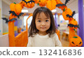 一名 3 歲女孩在室內秋季萬聖節裝飾前微笑 132416836