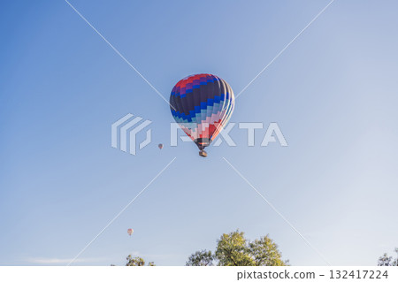 Hot air balloon floating in the clear sky, symbolizing freedom, wanderlust, and unique travel adventure. Perfect concept for tourism, summer holidays, and inspirational exploration Hot air balloon floating in the clear sky, symbolizing freedom, wanderlust, and unique travel adventure. Perfect concept for tourism, summer holidays, and inspirational exploration 132417224