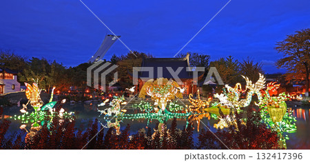 Chinese Garden illuminated at night with colorful figurines reflected on water, Chinese Pavilion and Stadium tower Chinese Garden illuminated at night with colorful figurines reflected on water, Chinese Pavilion and Stadium tower 132417396