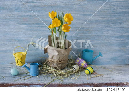 Spring Easter decor with crocuses and eggs. Crocuses and Easter eggs on a rustic wooden background. Spring Easter decor with crocuses and eggs. Crocuses and Easter eggs on a rustic wooden background. 132417401