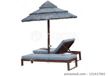 Thatched parasol shading two lounge chairs on white background 132417981
