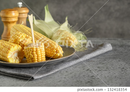 Freshly Cooked Corn Cobs in plate on gray background. Close up Freshly Cooked Corn Cobs in plate on gray background. Close up 132418354