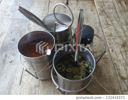 Spice caddy metal containers jalapeno chili flakes vinegar spoon rustic table condiment set add lively flavor 132418371