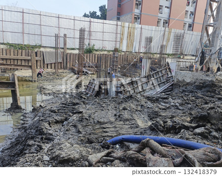 Construction site mud foundation work rebar concrete form urban building worker steel wet ground Construction site mud foundation work rebar concrete form urban building worker steel wet ground 132418379