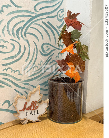 Hello fall decor with coffee beans and autumn leaves. Warm seasonal atmosphere, cafe aesthetics and cozy interior celebrating the arrival of autumn. Hello fall decor with coffee beans and autumn leaves. Warm seasonal atmosphere, cafe aesthetics and cozy interior celebrating the arrival of autumn. 132418507