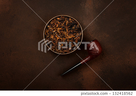 Tin of coarse cut tobacco and pipe over brown Tin of coarse cut tobacco and pipe over brown 132418562