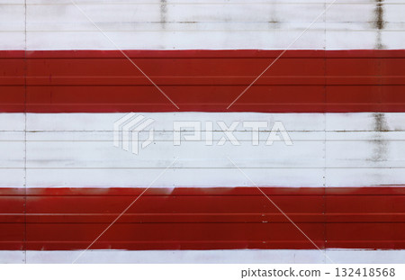 Weathered red and white stripes creating abstract pattern on metal wall Weathered red and white stripes creating abstract pattern on metal wall 132418568