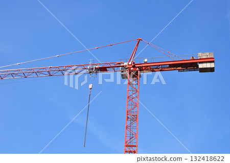 Red towering crane lifting against clear blue sky Red towering crane lifting against clear blue sky 132418622