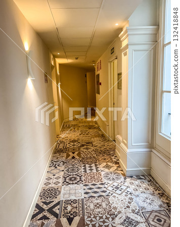 Bright Hallway with Patterned Tile Floor and Wall Lights 132418848