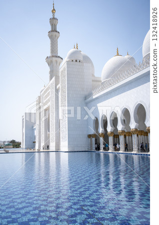 Vertical shot of beautiful white mosque with water in foreground, United Arab Emirates Vertical shot of beautiful white mosque with water in foreground, United Arab Emirates 132418926