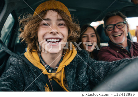 Happy teenager driving car with parents smiling during family trip Happy teenager driving car with parents smiling during family trip 132418989