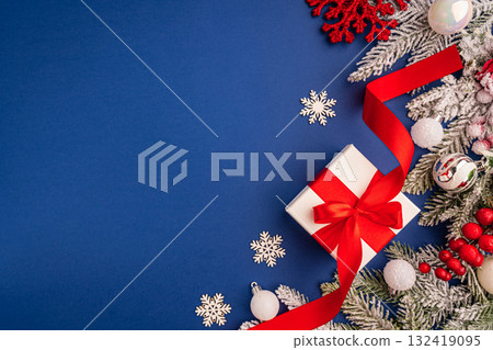Christmas Gift with Red Ribbon and Snowy Festive Decorations Christmas Gift with Red Ribbon and Snowy Festive Decorations 132419095
