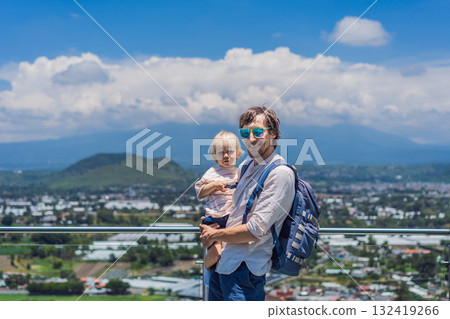 Father and his little son standing together in front of Popocatepetl volcano surrounded by clouds, enjoying a peaceful and heartwarming family travel moment in Mexico Father and his little son standing together in front of Popocatepetl volcano surrounded by clouds, enjoying a peaceful and heartwarming family travel moment in Mexico 132419266