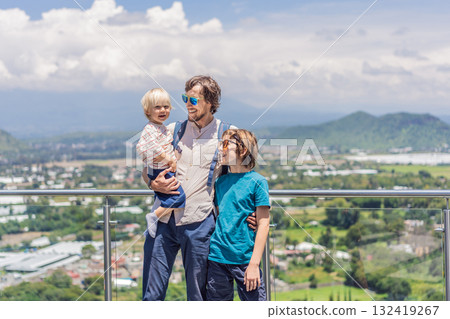 Father with his two sons standing in front of Popocatepetl volcano in Mexico, surrounded by clouds, enjoying a scenic family adventure and breathtaking outdoor view Father with his two sons standing in front of Popocatepetl volcano in Mexico, surrounded by clouds, enjoying a scenic family adventure and breathtaking outdoor view 132419267