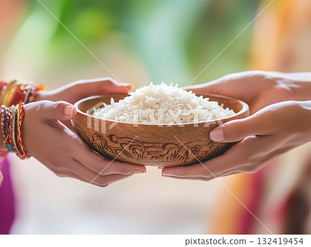 Sharing Sacred Rice in Traditional Carved Wooden Bowl 132419454