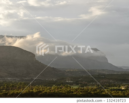 serene dawn over green valley, morning clouds cascade over sandstone cliffs into sunlit valleys serene dawn over green valley, morning clouds cascade over sandstone cliffs into sunlit valleys 132419723