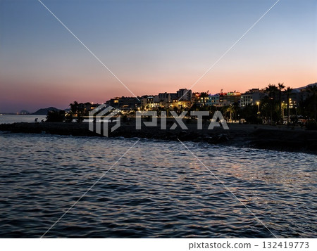 calm evening by coast, tranquil evening stroll on seaside with glowing skyline and gentle waves 132419773