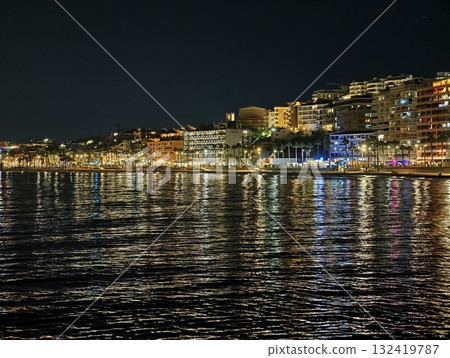 vibrant seaside nightlife, bright seaside evening with illuminated facades and lively music vibrant seaside nightlife, bright seaside evening with illuminated facades and lively music 132419787