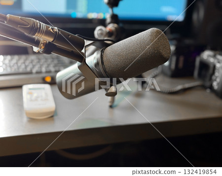 Studio microphone on desk with blurred background and soft lighting. Sound recording, podcast production and creative workspace for voice and music creation. Studio microphone on desk with blurred background and soft lighting. Sound recording, podcast production and creative workspace for voice and music creation. 132419854