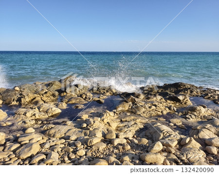 tranquil blue ocean with rugged rocks, peaceful blue waters embrace resistant rocks under morning 132420090