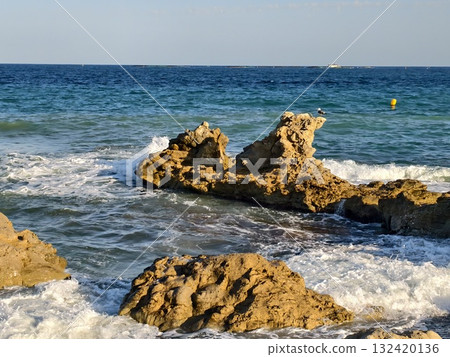 vivid ocean scene, dynamic shoreline with waves, energetic beach landscape with surf and stones 132420136