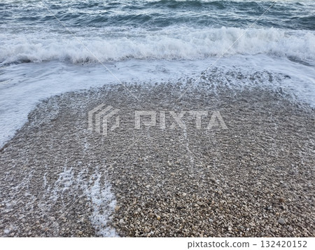 serene beach setting featuring rhythmic wave motion and contrasting pebble textures at shoreline serene beach setting featuring rhythmic wave motion and contrasting pebble textures at shoreline 132420152