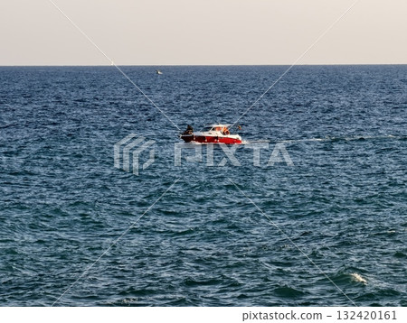 relaxing speedboat ride across tranquil waters, calm red boat sailing smoothly over expansive blue 132420161