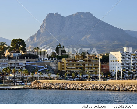 waterfront hotel with mountain views, relaxing seaside resort with mountain backdrop and sunset waterfront hotel with mountain views, relaxing seaside resort with mountain backdrop and sunset 132420164