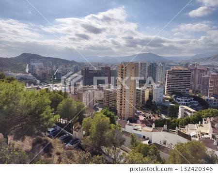 sunlit rooftops and distant horizon, urban hillside overlooking city skyline with mountain backdrop sunlit rooftops and distant horizon, urban hillside overlooking city skyline with mountain backdrop 132420346