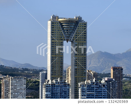 city and mountains in daylight, city skyline with towering buildings and mountain background 132420369